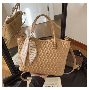Detalle de bolso shopper beige acolchado con pañuelo de seda de corazones y correa fina