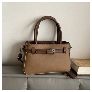 Détail du sac bandoulière en toile fauve avec finitions cuir et boucle en métal argenté