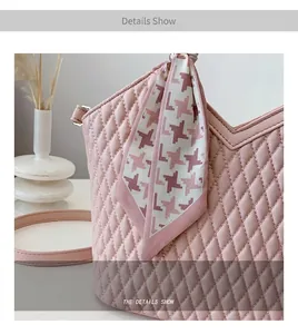 Détail d'un sac cabas rose matelassé avec une écharpe chic en soie à motif pied-de-poule