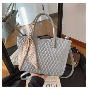 Detalle del bolso acolchado azul claro en piel con pañuelo de seda decorativo y asa