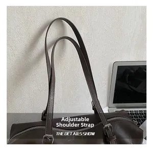 Detail of adjustable leather shoulder strap with metal buckle on dark brown tote bag