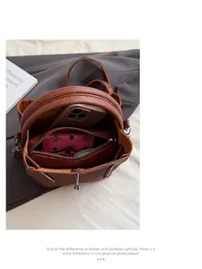 Dettaglio dell'interno della borsa a secchiello in pelle marrone con pochette a zip