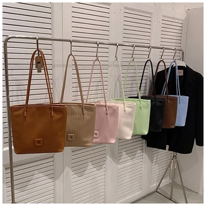 Détail de sacs fourre-tout à rayures en huit couleurs élégantes sur un support métallique