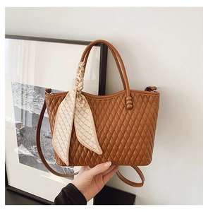 Detalles del bolso tote acolchado marrón con un pañuelo de seda floral envuelto en el asa