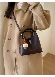 Detail of dark brown pebble leather bucket bag with silver lock and ice cream charm
