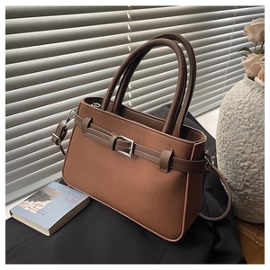 Détail du sac bandoulière vintage marron avec texture textile et boucle argentée