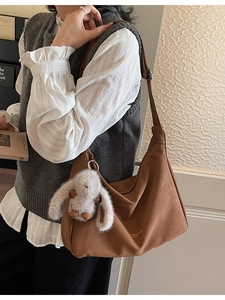 Bolso bandolera vintage marrón con colgante de conejo de peluche mostrado en modelo