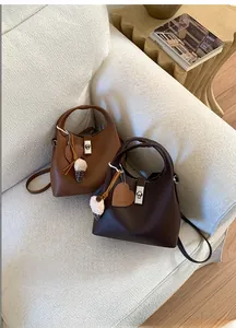 Detailed view of lychee pattern leather bucket bag with heart tag and plush charm