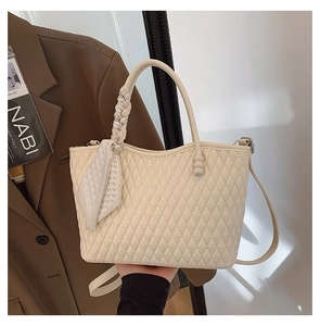 Detalle del bolso acolchado blanco roto con asa de pañuelo de seda y textura de cuero