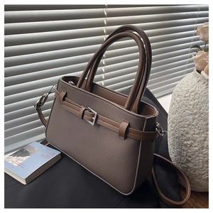 Détail du sac bandoulière en toile marron café avec boucle en métal et texture cuir