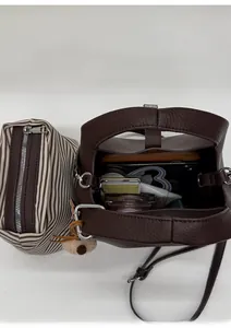 Detail view of brown lychee leather bucket bag with a striped inner pouch and large capacity