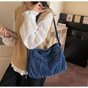 Detailed embroidery of NUBELETING logo on a large blue denim hobo tote bag for women