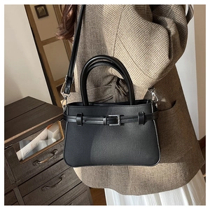 Détail d'un sac à main structuré noir mat avec boucle argentée et bandoulière