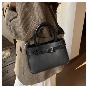 Détail du sac à bandoulière en cuir noir avec boucle et bandoulière amovible