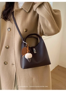 Detail of lychee pattern leather bucket bag with metal lock and plush ice cream charm