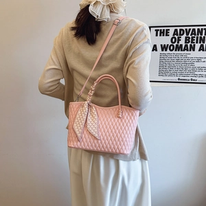 Bolso tote rosa acolchado con pañuelo de seda usado cruzado por una modelo