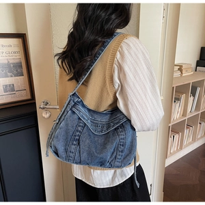 Détail du sac à épaule en jean vintage avec rubans à cordon latéraux et imprimé lettres
