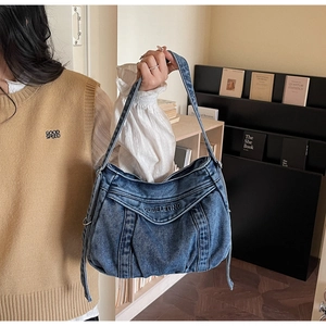 Gros plan d'un sac hobo en jean délavé avec texture plissée et bandoulière élégante