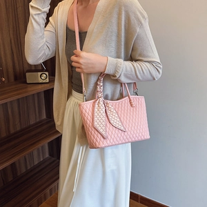 Detalle de bolso acolchado rosa con pañuelo de seda en el asa y correa de hombro fina