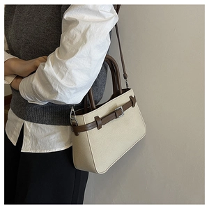 Sac à main minimaliste crème et marron porté en bandoulière sur un mannequin