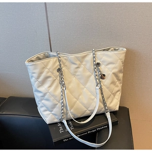 Detail showing creamy white quilted PU leather tote with silver chain shoulder strap