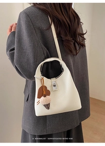 Detail of white lychee leather bucket bag with silver clasp and heart ice cream charm