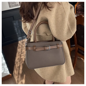 Détail d'un sac à bandoulière vintage avec texture mate et boucles métalliques