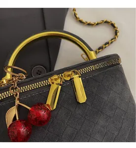 Close-up of a woven texture bag with gold ring handle and double zipper details