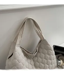Detail showing the quilted puffer texture and sturdy handle of the white tote bag