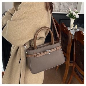 Détail du sac à bandoulière en cuir marron avec boucle argentée et lanière ajustable