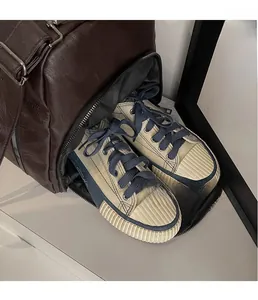 Détail macro du compartiment à chaussures latéral du sac de voyage marron zippé