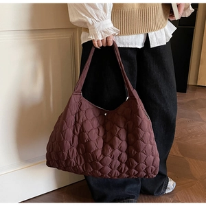 Quilted oversized dark brown tote bag shown in a lifestyle setting for casual daily use