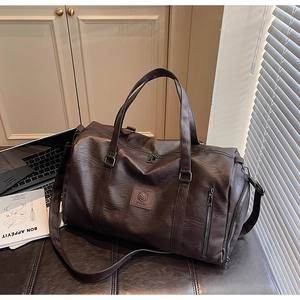 Détails d'un sac de sport en cuir marron foncé avec doubles poignées et bandoulière