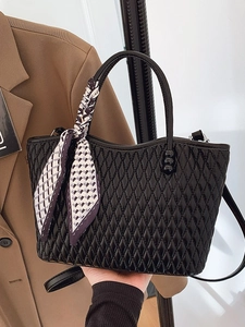 Elegante bolso de mano acolchado negro con acabado brillante y bufanda morada en el asa