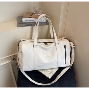 Détail du grand sac de voyage blanc avec poignées renforcées et texture en similicuir PU