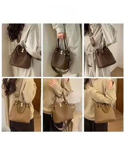 Detail view of large bucket bag with wide woven strap and litchi grain leather texture