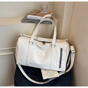 Vue détaillée du grand sac de voyage blanc avec doubles poignées et bandoulière