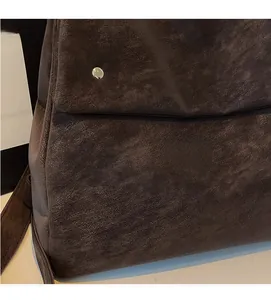 Detail of dark brown vintage faux leather texture with a silver metallic magnetic buckle