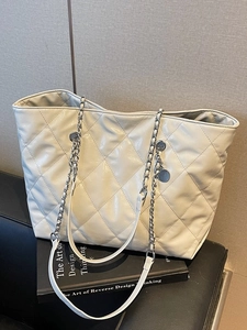 Chic quilted beige tote bag with large diamond pattern and metal chain strap details
