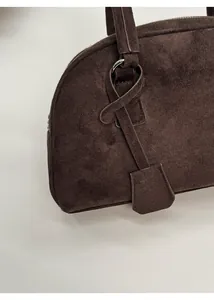 Close-up of matte coffee leather Boston bag showing stitching and silver hardware detail