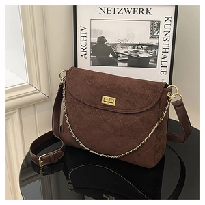 Detail der gesteppten dunkelbraunen Wildledertasche mit goldenem Drehverschluss