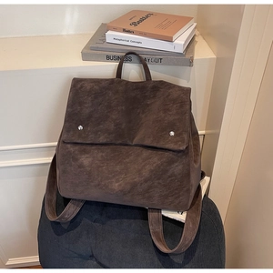 Detail of dark brown vintage leather backpack with wide straps and matte texture