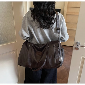 Détail macro du sac de fitness en cuir PU marron foncé avec bandoulière réglable