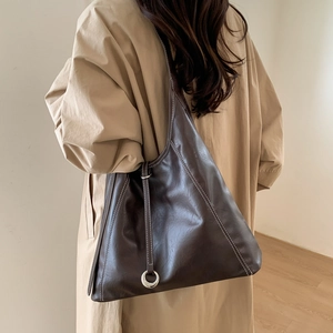 Detail view of dark brown tote bag with contrast stitching and metal ring decor