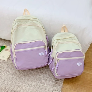 Detailed view of beige and lavender nylon backpacks in two sizes with zip pockets