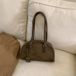 Macro shot of dark olive green suede pillow bag with vintage metal buckle and long strap