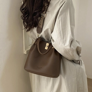 Deep brown pebble leather bucket bag with vintage woven strap and gold twist lock