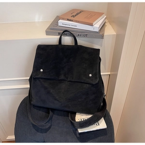 Detail of minimalist black matte texture backpack with flap cover and silver metal rivets