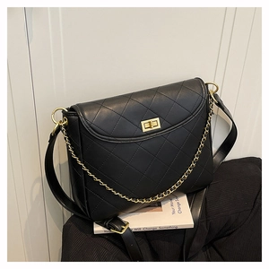 Detail der klassisch schwarzen Stepptasche mit goldenem Metalldrehverschluss und Kettenriemen