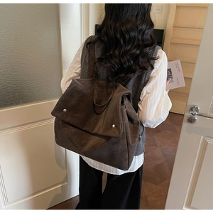 Macro view of dark brown frosted leather backpack with large flap and top handle detail